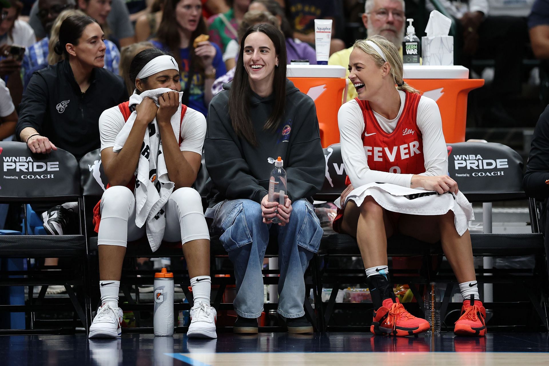 Sydney Colson #51, Caitlin Clark #22 and Sophie Cunningham #8 of the Indiana Fever watch action during a game against the Dallas Wings at American Airlines Center on June 27, 2025 in Dallas, Texas. - Source: Getty